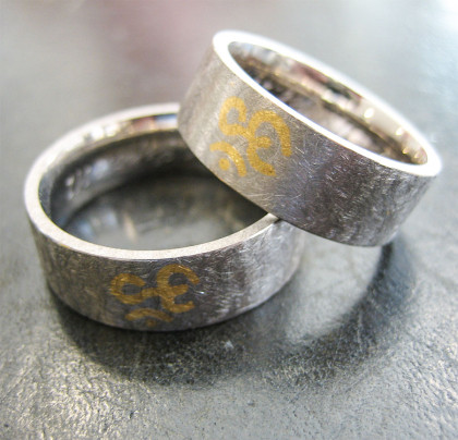 Trauringe - Weissgold mit Ohm-Motiv in Feingold